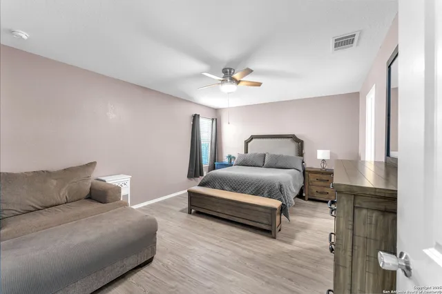 a bedroom with a bed chandelier and a couch
