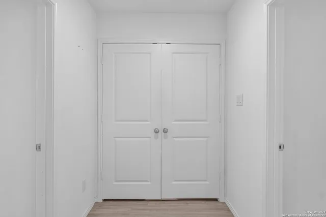 a view of hallway with closet and wooden floor