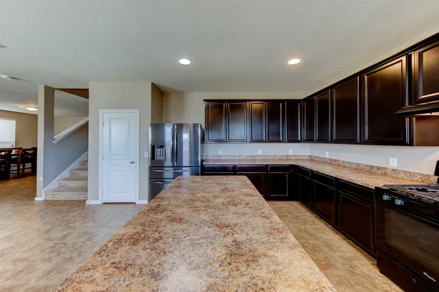 a kitchen with stainless steel appliances granite countertop a refrigerator and a sink