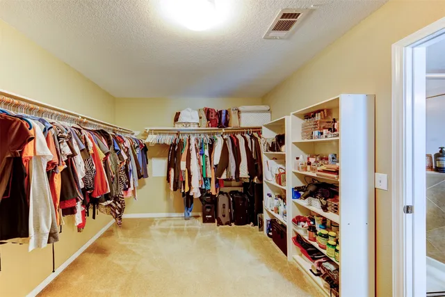 a view of walk in closet with clothes and shoes