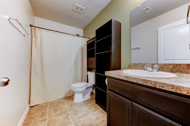 a bathroom with a granite countertop sink toilet and shower