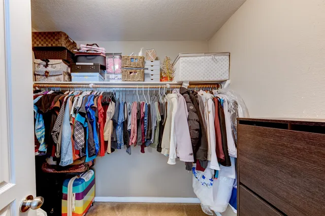 a view of walk in closet with clothes