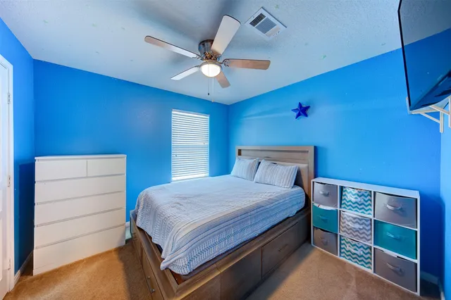 a bedroom with a bed and a ceiling fan