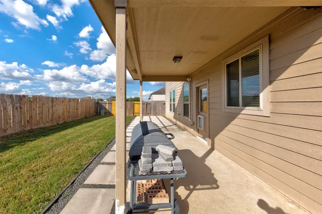 a view of a patio with table and chairs with wooden floor and fence