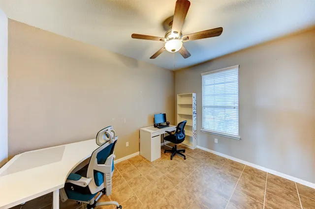 a view of a workspace with furniture and a window