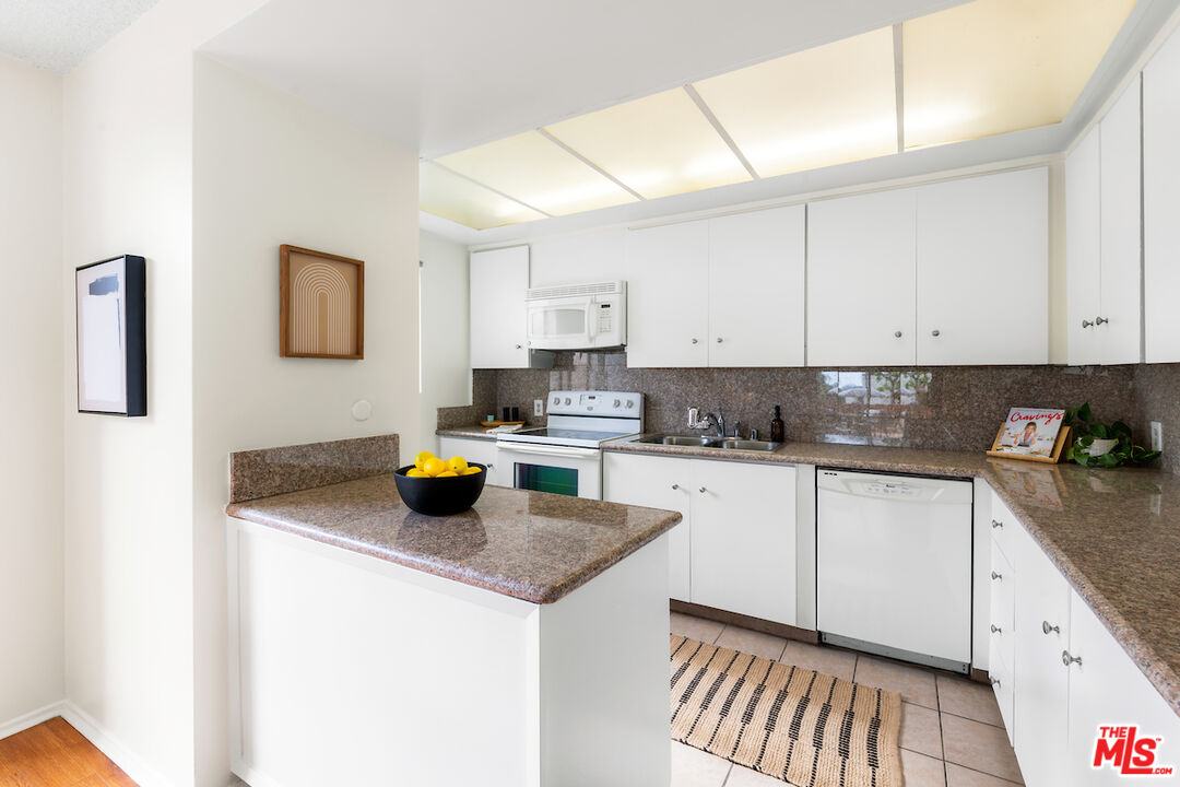 1401 Valley View Road, Unit 118 Glendale, CA 91202 - Photo 10 of 23 a kitchen with stainless steel appliances granite countertop a sink stove and white cabinets