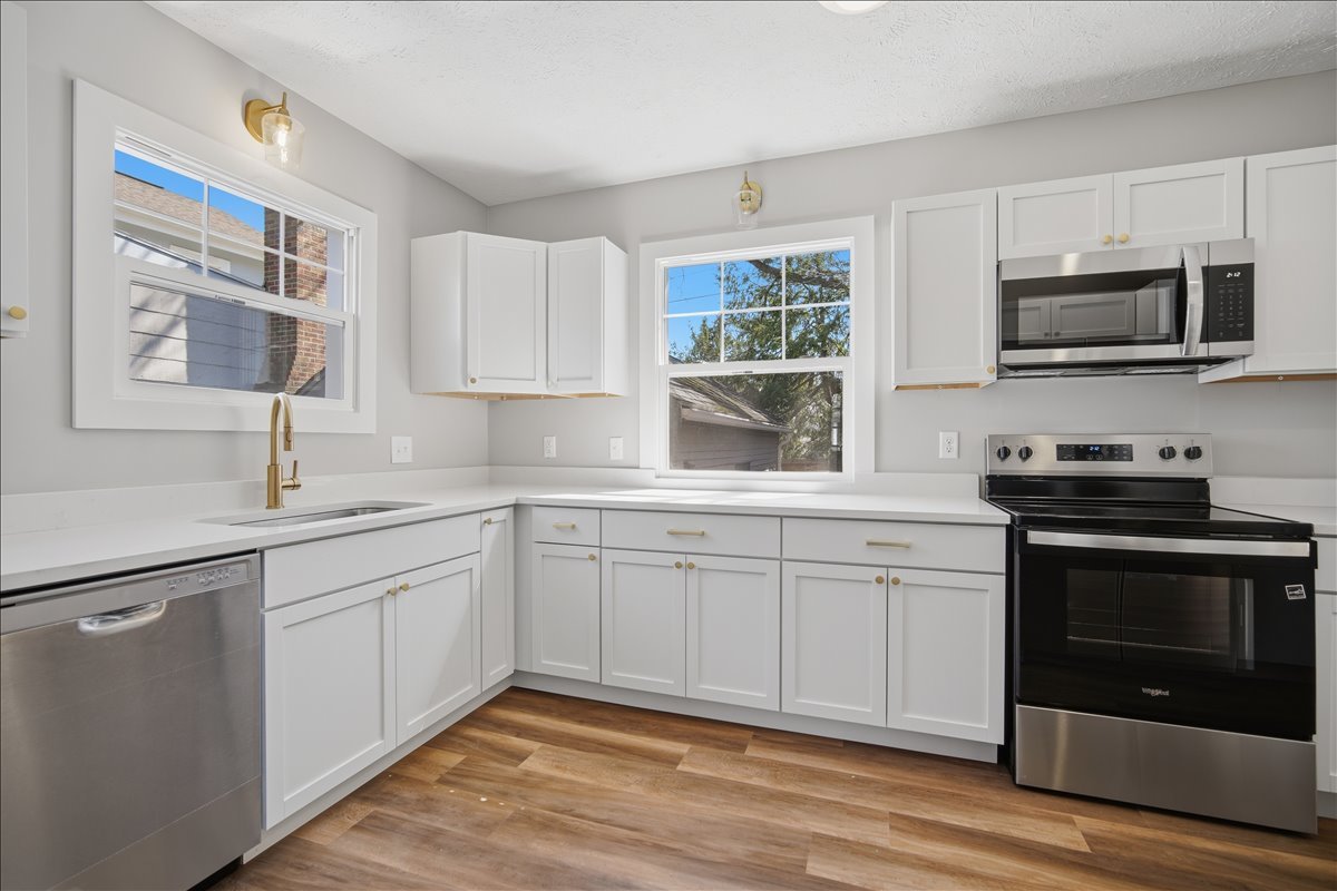 503 East Chestnut Street Bloomington, IL 61701 - Photo 3 of 24 a kitchen with stainless steel appliances granite countertop a sink and a stove top oven