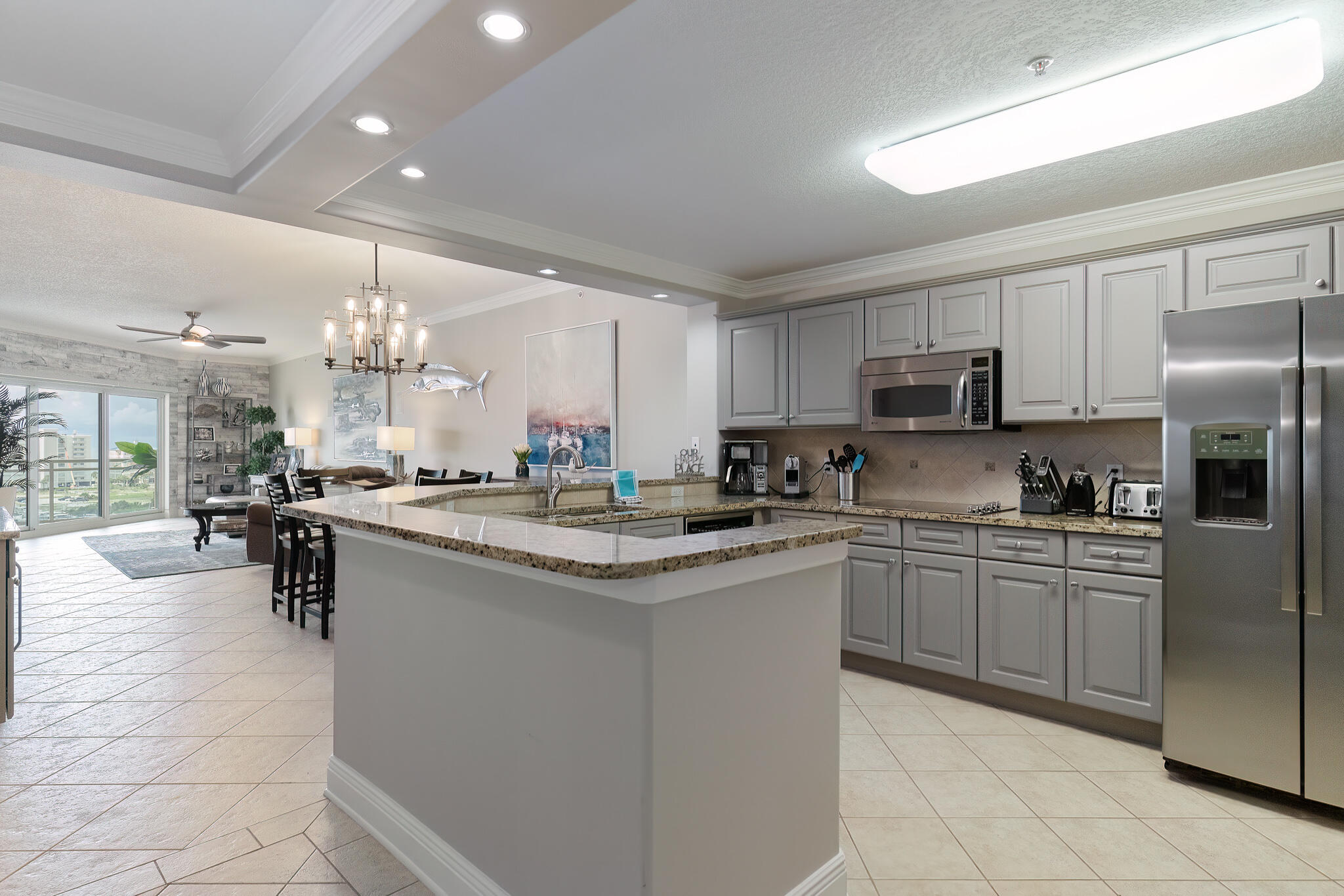 770 Harbor Boulevard, Unit 7E Destin, FL 32541 - Photo 10 of 50 a kitchen with kitchen island granite countertop a sink counter top space appliances and cabinets