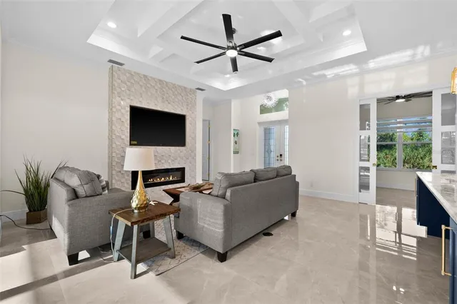 a living room with furniture a fireplace and a ceiling fan