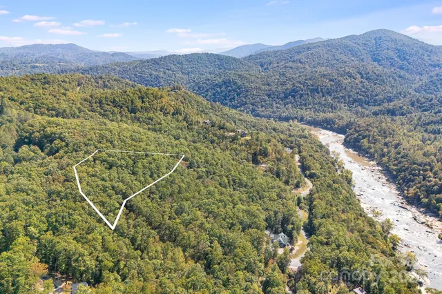 a view of a lush green field with mountains in the background