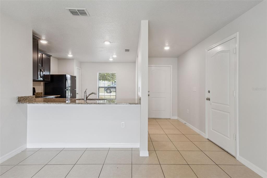 1613 Orne Street Mascotte, FL 34753 - Photo 4 of 31 a view of kitchen with refrigerator sink and microwave