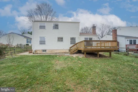 a view of house with a backyard and a wooden deck