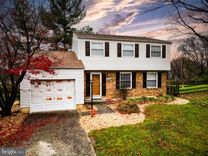 aerial view of a house with a yard and large trees