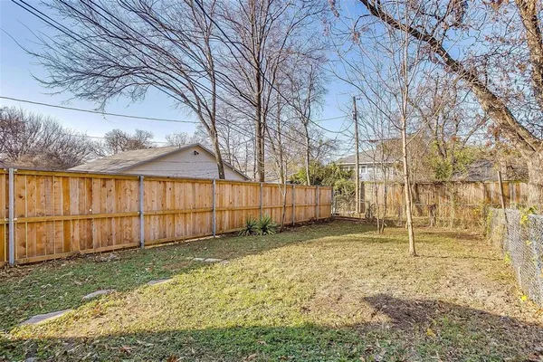 a backyard of a house with a small yard and large tree