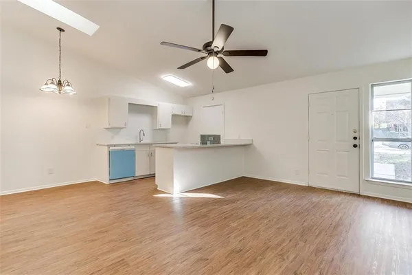 a view of a kitchen with wooden floor and a ceiling fan