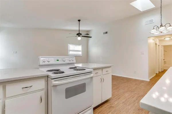 a kitchen with a stove and white cabinets