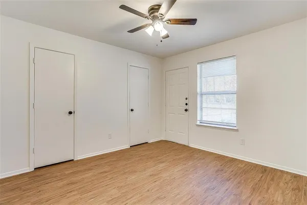 a view of a room with wooden floor and a ceiling fan
