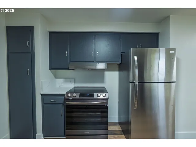 a kitchen with a refrigerator and a stove