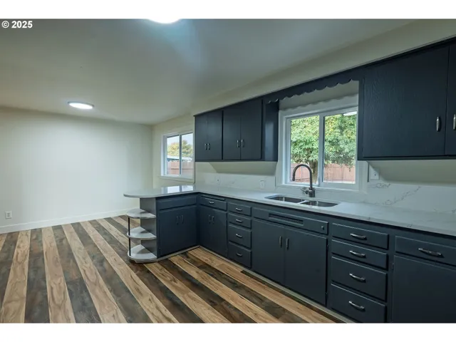 a kitchen with wooden floors and wooden cabinets