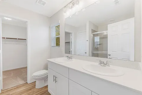 a bathroom with a sink a toilet and a mirror