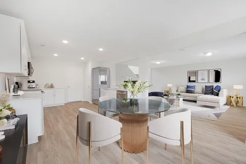 a view of kitchen with refrigerator stove dining table and chairs