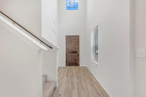 a view of a hallway with wooden floor and entryway
