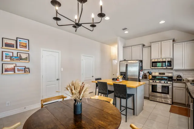 a work room with stainless steel appliances furniture a rug and a window
