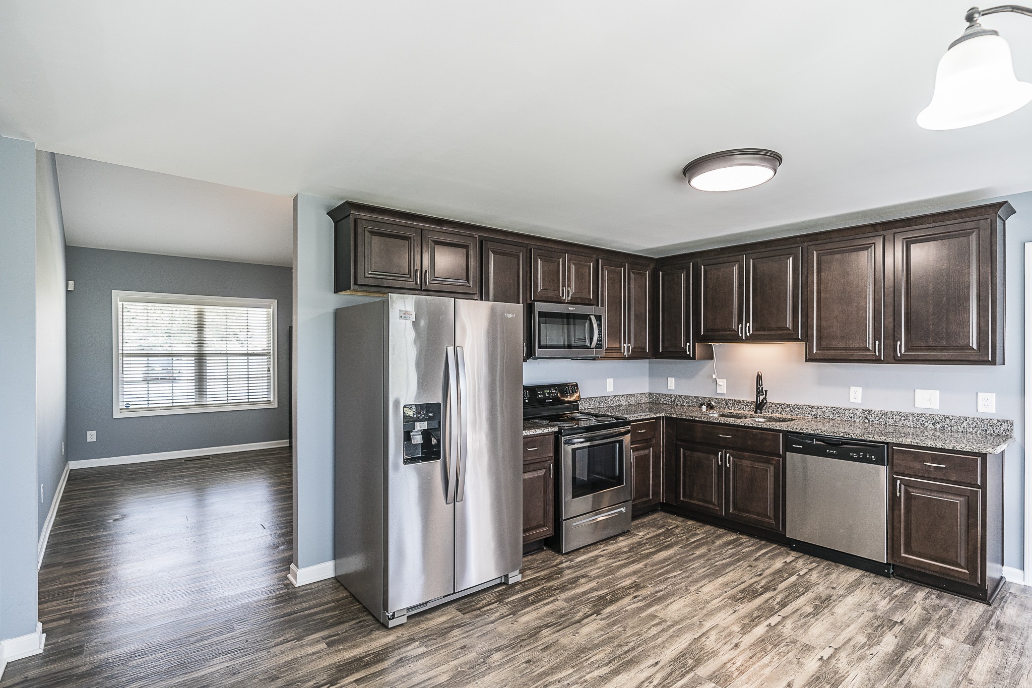 212 Scattersville Road Portland, TN 37148 - Photo 36 of 63 a kitchen with stainless steel appliances granite countertop a refrigerator a sink dishwasher a stove with wooden cabinets and floor