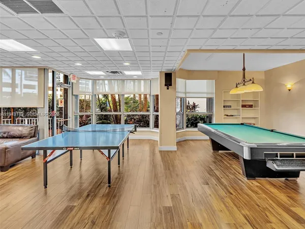 a living room with stainless steel appliances dining table chairs and a chandelier