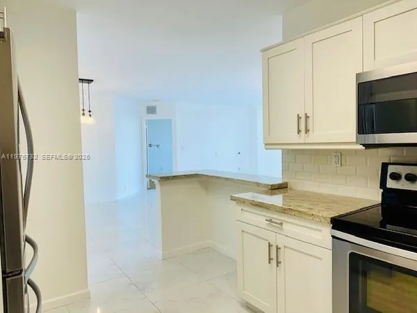 a kitchen with stainless steel appliances white cabinets and a stove top oven