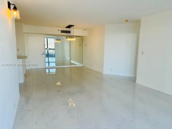 an empty room with kitchen view and mirror