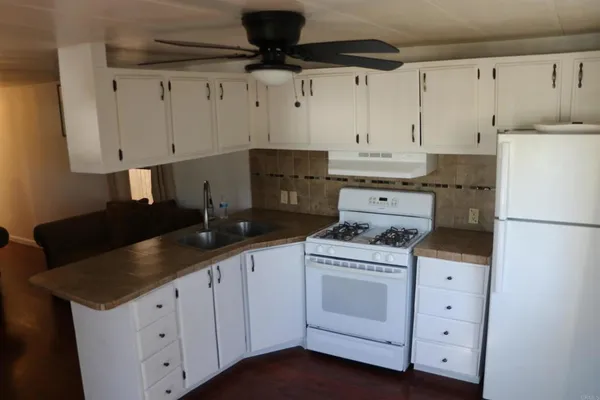 a kitchen with granite countertop white cabinets and white appliances