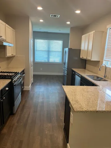 a kitchen with granite countertop a stove and a sink