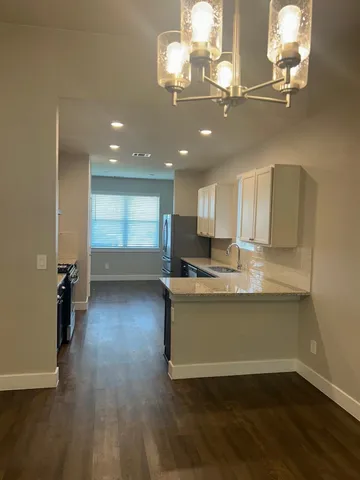 a view of a room with wooden floor and chandelier