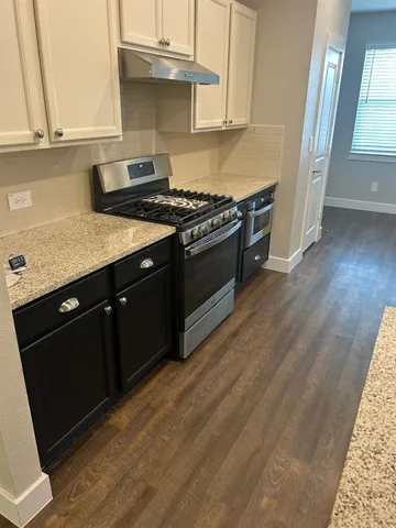 a kitchen with stainless steel appliances granite countertop a stove a sink and a microwave