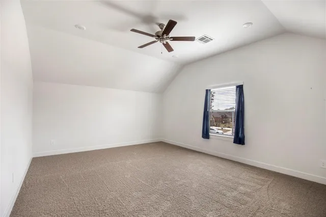 an empty room with windows and ceiling fan