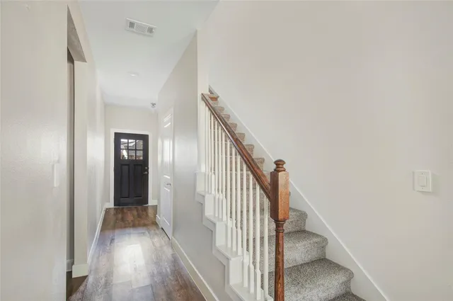 a view of a hallway with wooden floor and entryway