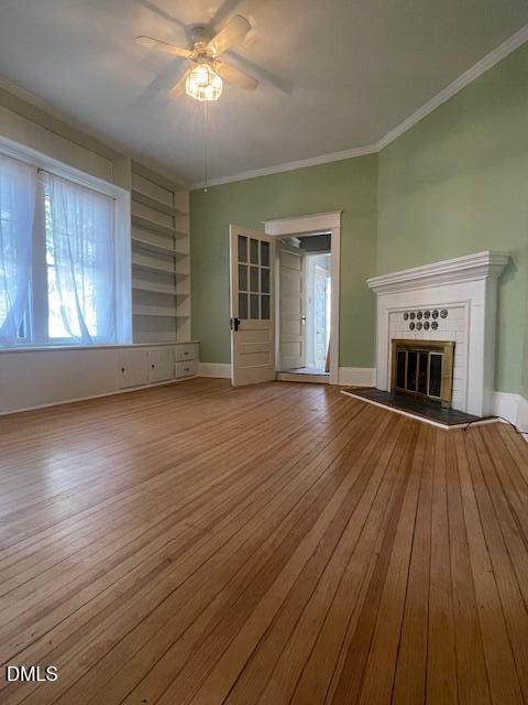 216 Hillcrest Road Raleigh, NC 27605 - Photo 3 of 6 an empty room with wooden floor fireplace and windows