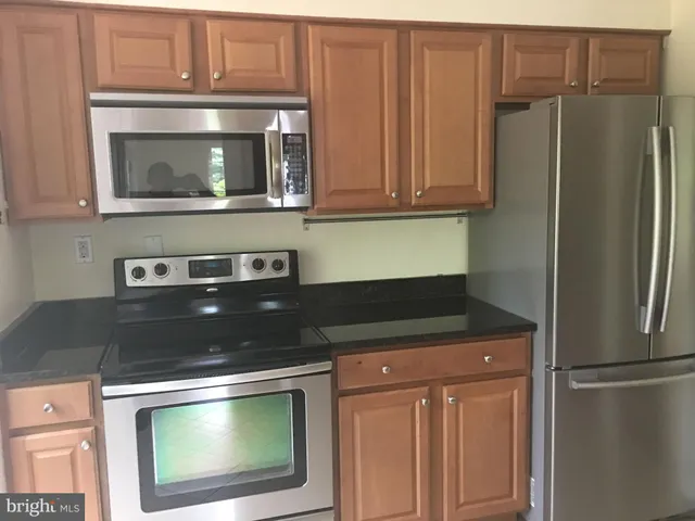 a kitchen with stainless steel appliances granite countertop a refrigerator and a microwave