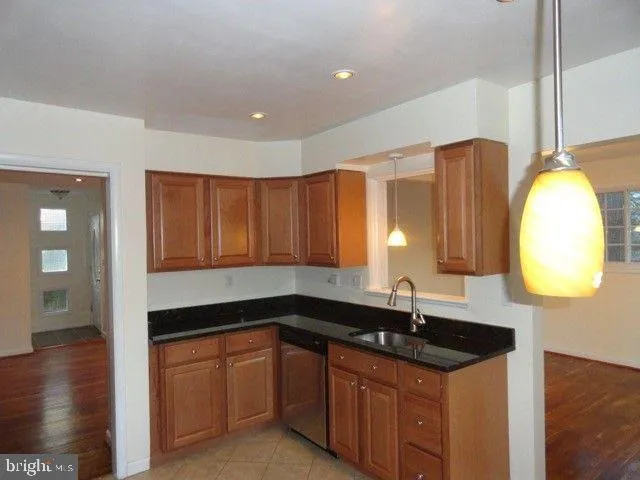 a kitchen with granite countertop a sink a counter space and cabinets