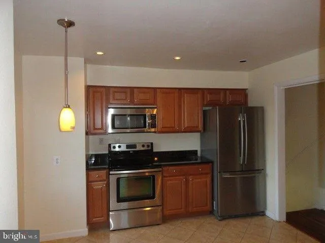 a kitchen with a refrigerator stainless steel appliances and cabinets