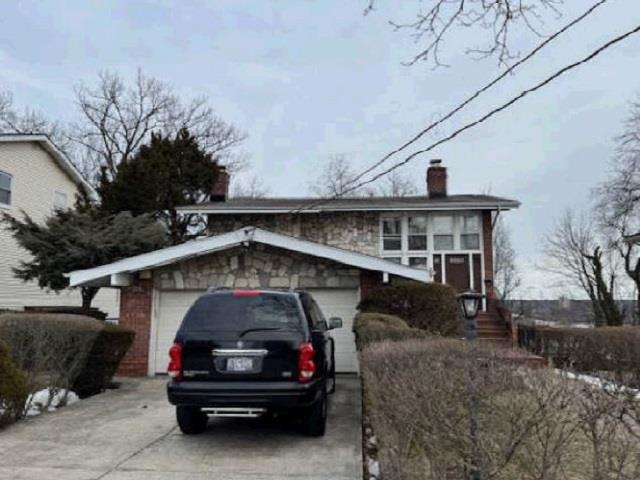 View of front of house featuring a chimney and driveway