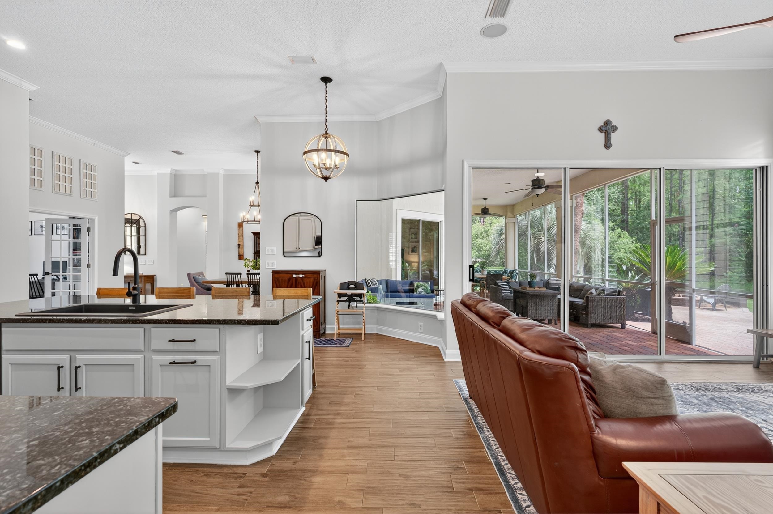641 Pelham Road St. Augustine, FL 32092 - Photo 62 of 62 Kitchen featuring open floor plan, open shelves, crown molding, white cabinetry, and dark stone countertops