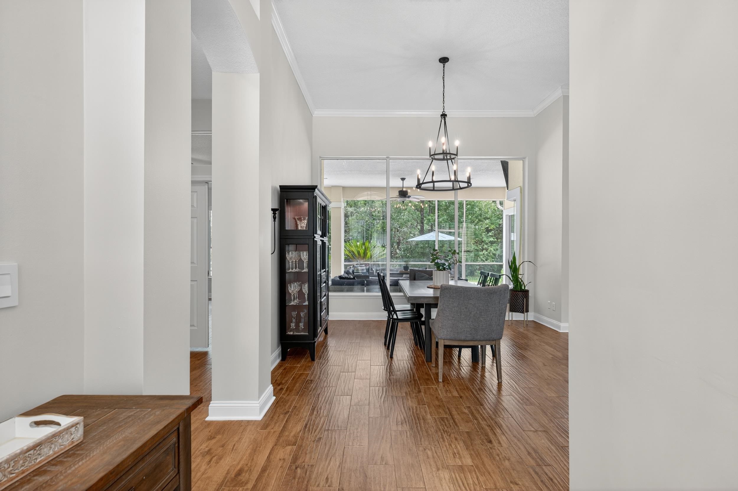 641 Pelham Road St. Augustine, FL 32092 - Photo 3 of 62 a dining room with furniture a chandelier and wooden floor
