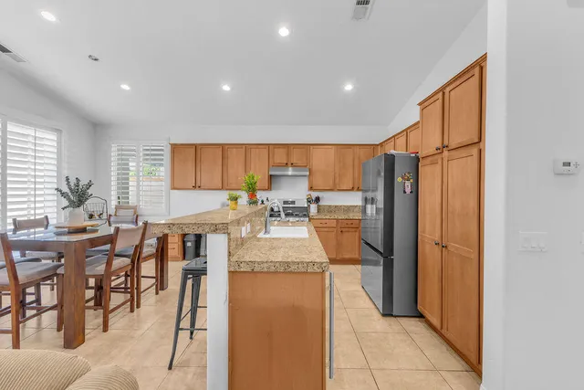 a kitchen with stainless steel appliances granite countertop a refrigerator and a stove top oven