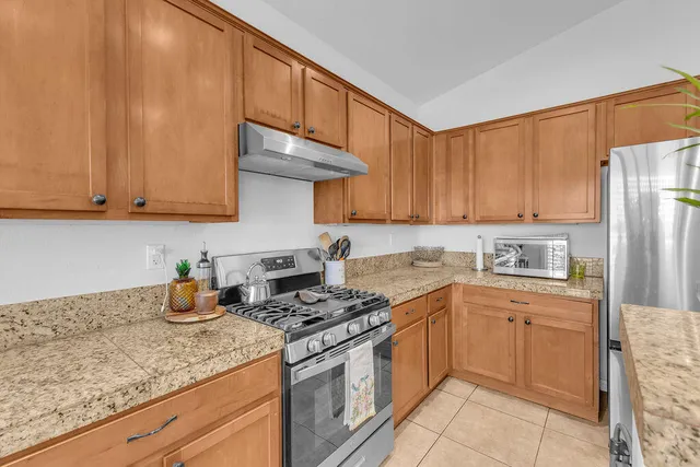 a kitchen with stainless steel appliances granite countertop a sink stove and refrigerator