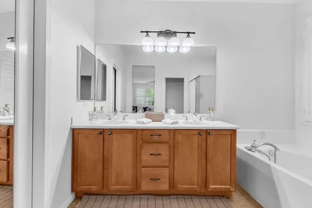 a bathroom with a granite countertop sink mirror and bathtub