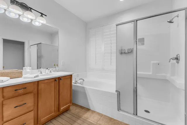 a bathroom with a bath tub sink mirror and shower