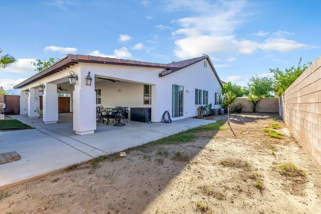 a view of a house with backyard and sitting area