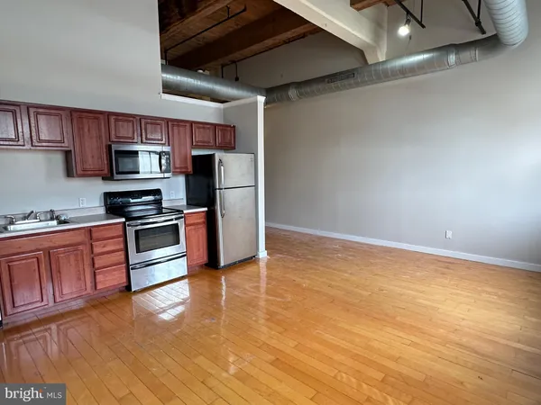 a kitchen with stainless steel appliances a stove a refrigerator and a microwave